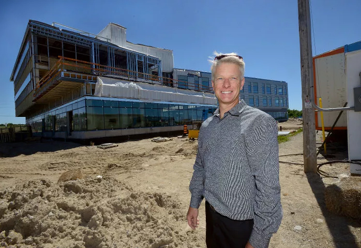 Member of the Sifton team, standing in front of a new office building at West 5